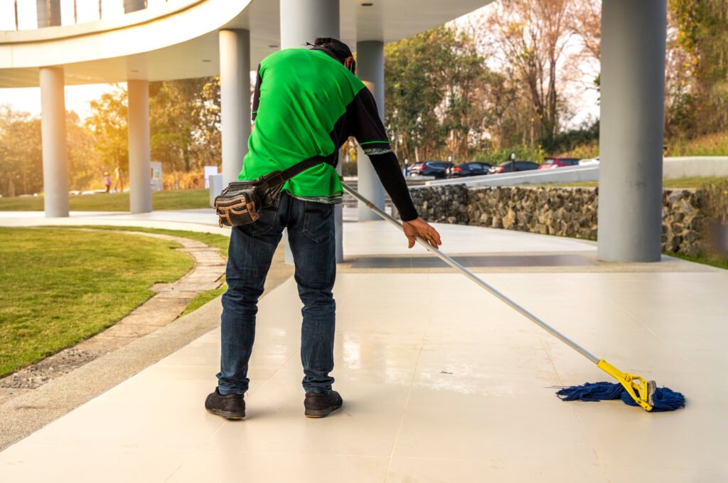 a janitor man cleaning mopping floor in office building or walkway modern building.