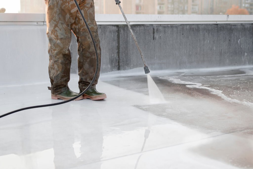 a person using high pressure equipment to clean the bottom of a water pool. cleaning dirt. before and after situation. uniform and rubber boots.