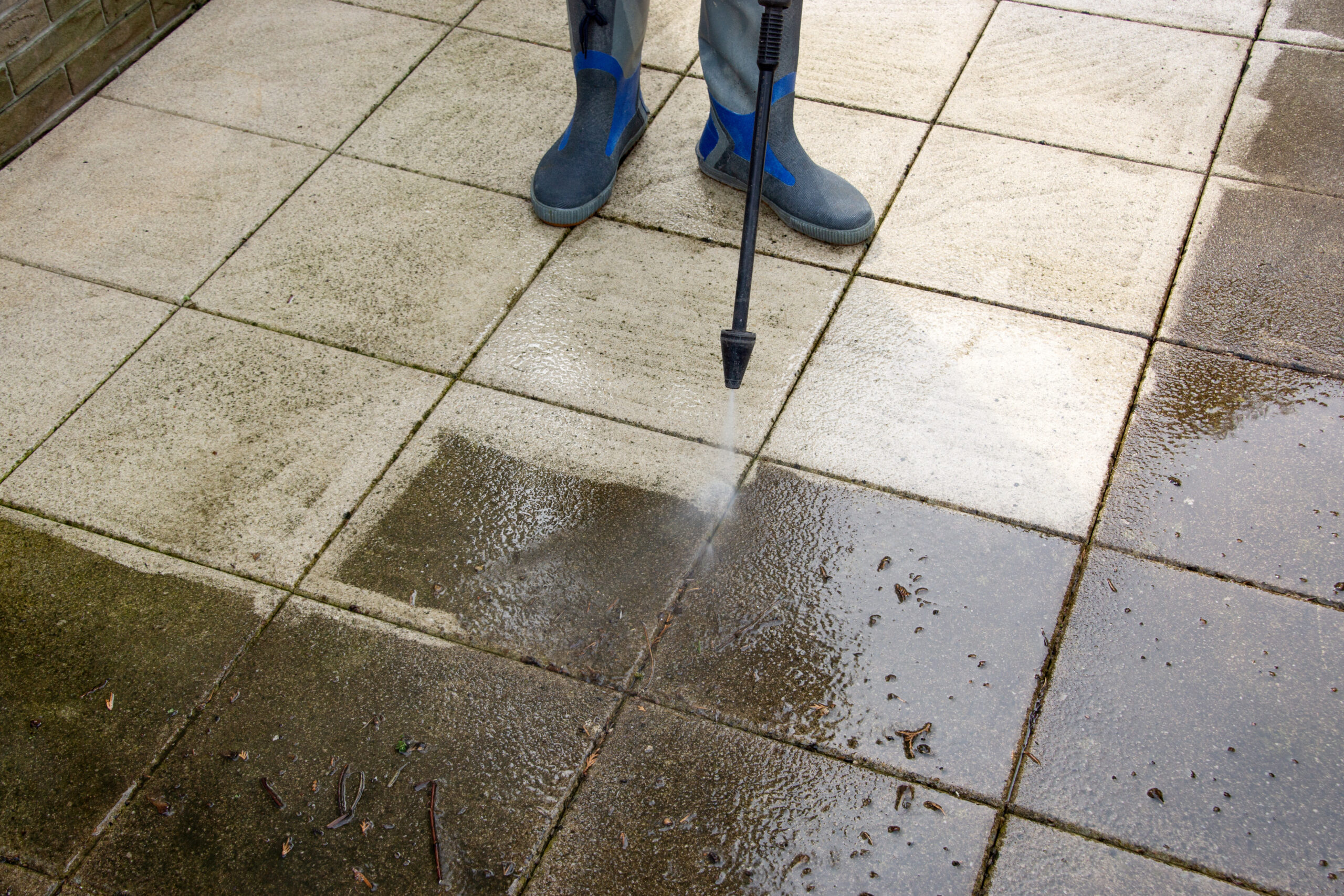 outdoor floor cleaning with high pressure water jet. man in rubb